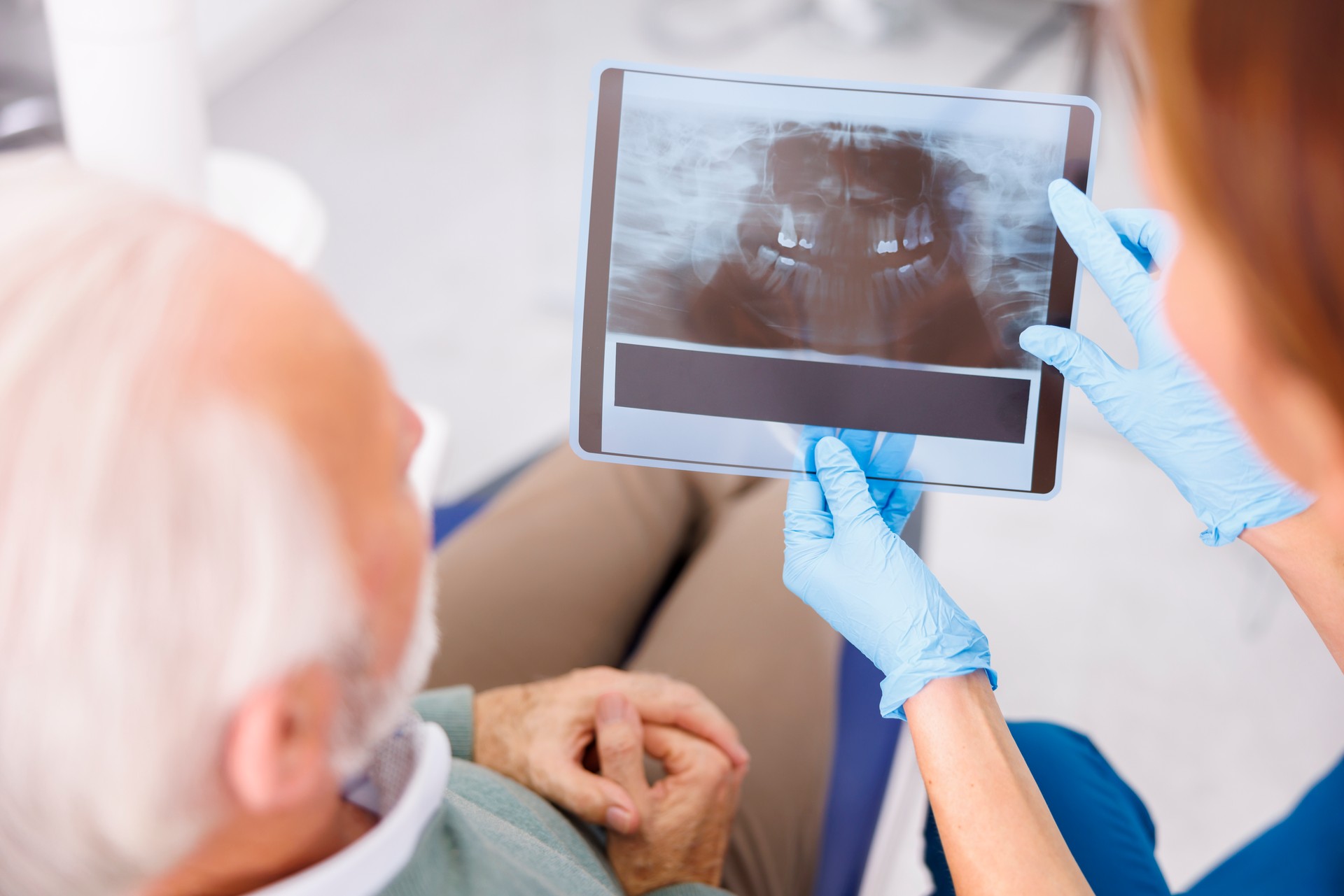 Dentist showing jaw x-ray to patient